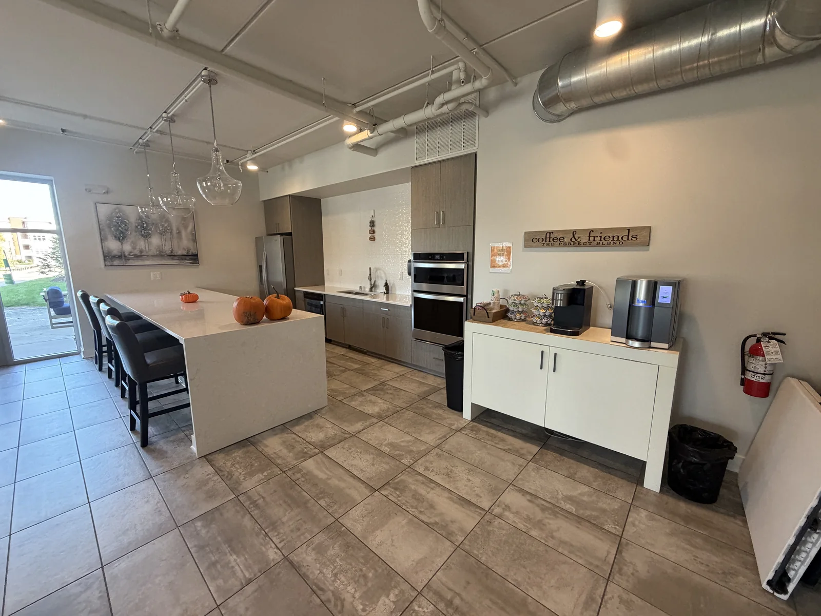 Apartment building common area with a shared kitchen, island seating and coffee station