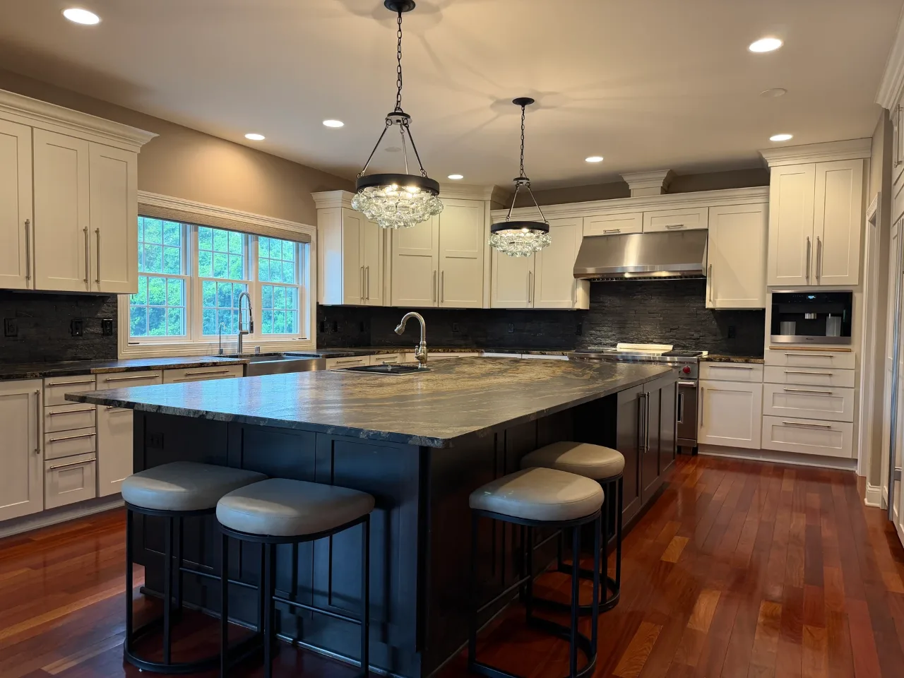 Finished kitchen with a stone island and cream cabinetry