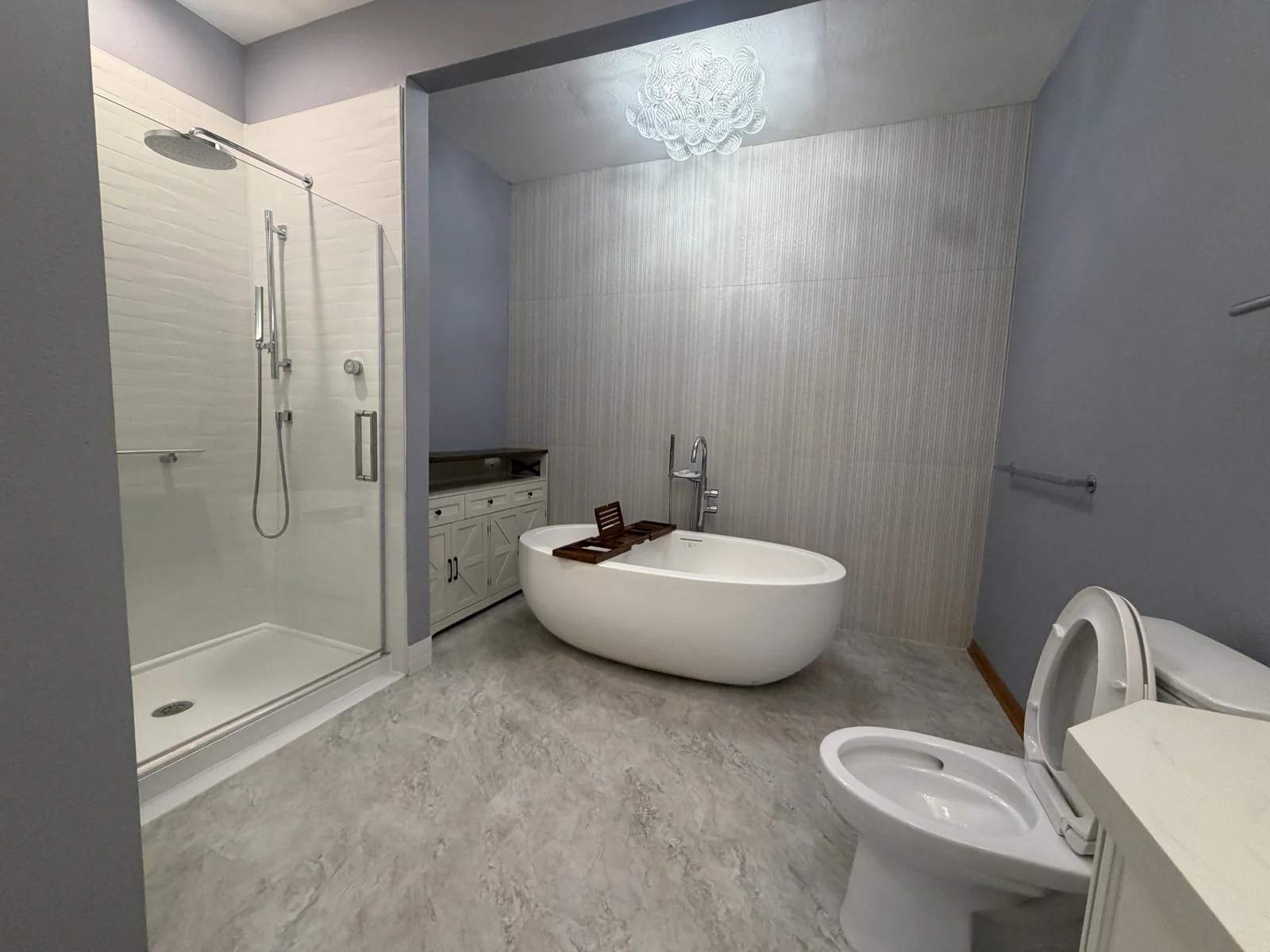 Residential bathroom with a glass shower, freestanding tub and tile floor