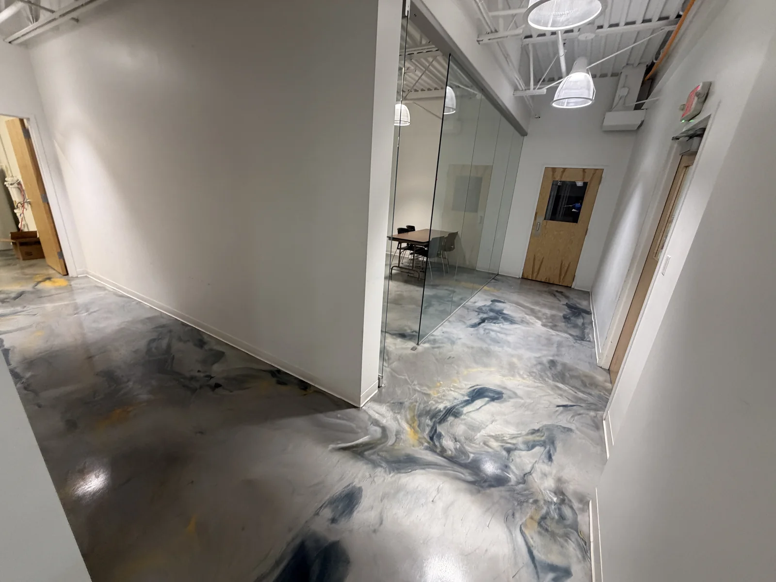 Office corridor with glass partitions and a patterned hard floor