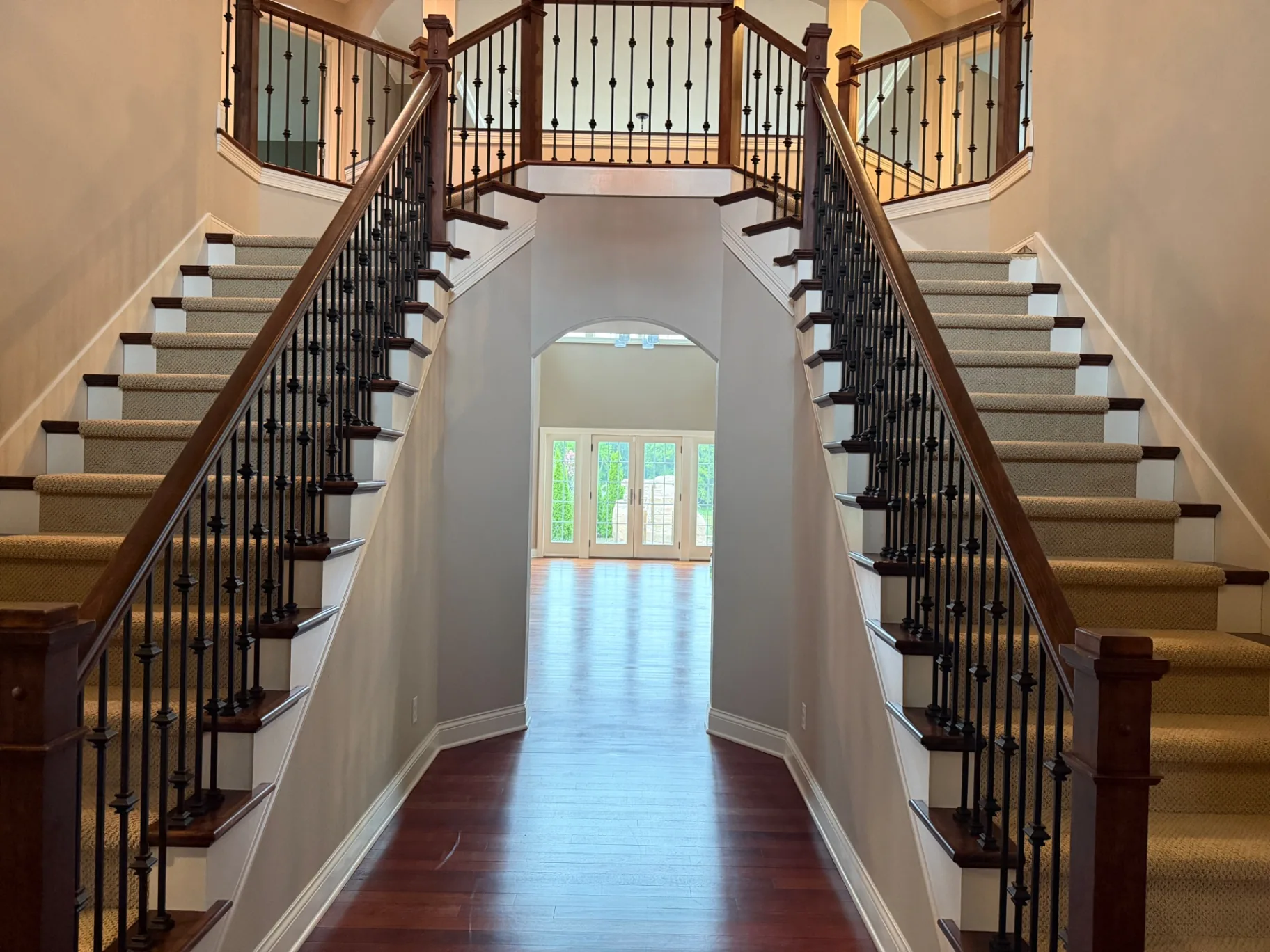 Double staircase foyer with freshly vacuumed carpet runners after a move-out clean