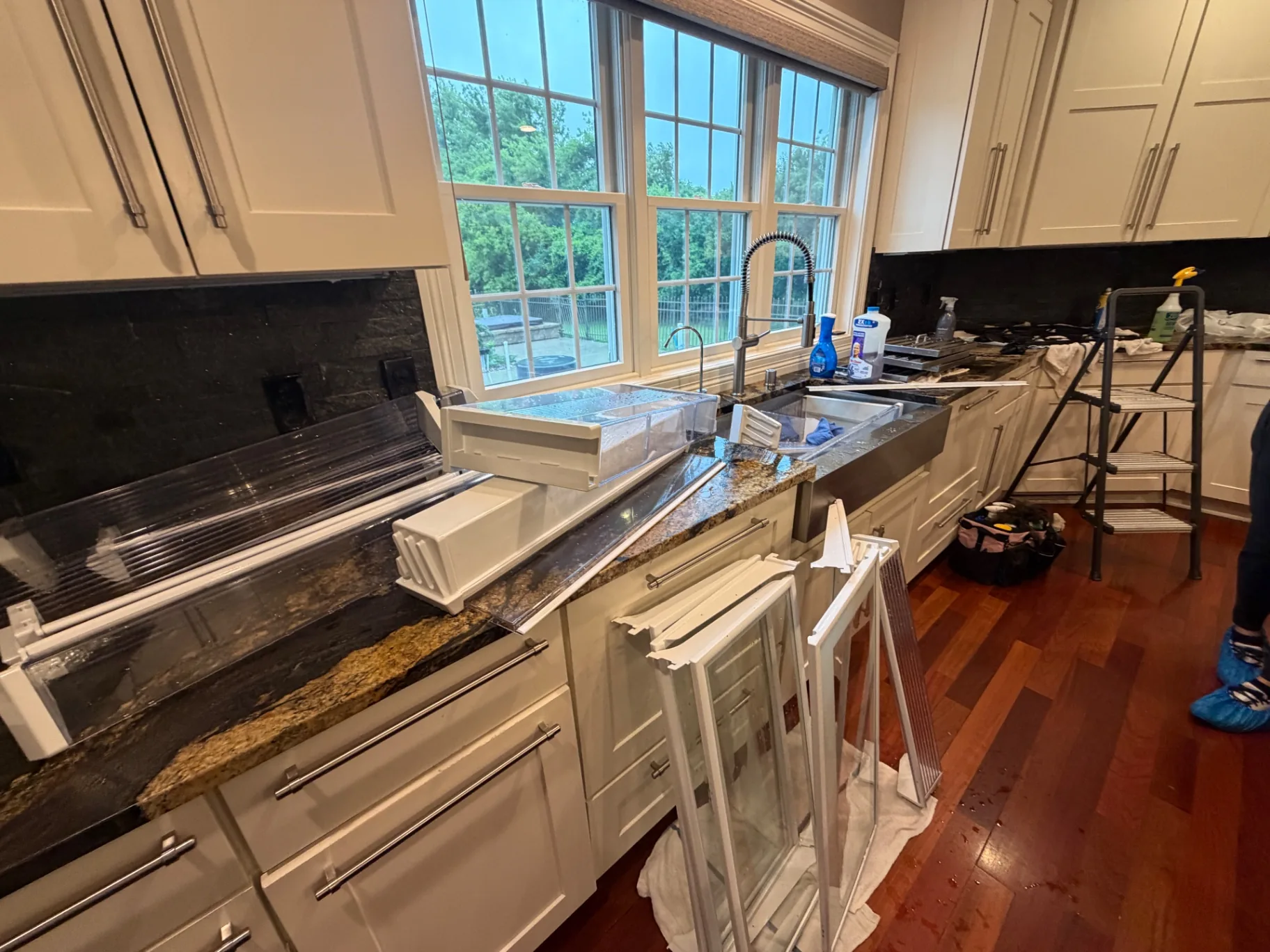 Mid-visit: refrigerator shelves and drawers removed and hand-washed at the sink