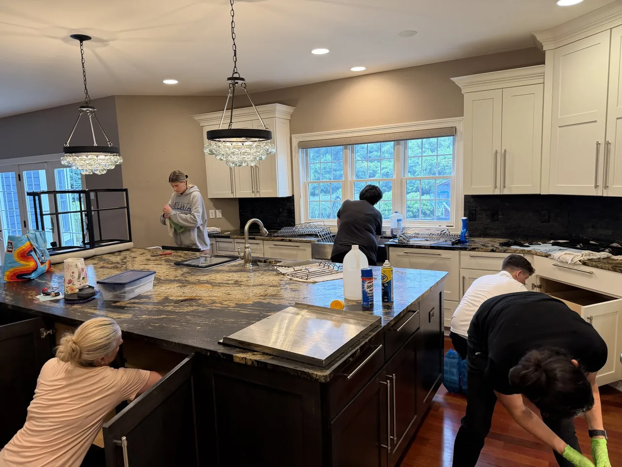 Star Pro cleaning team working together on a premium kitchen island, appliances, and cabinetry